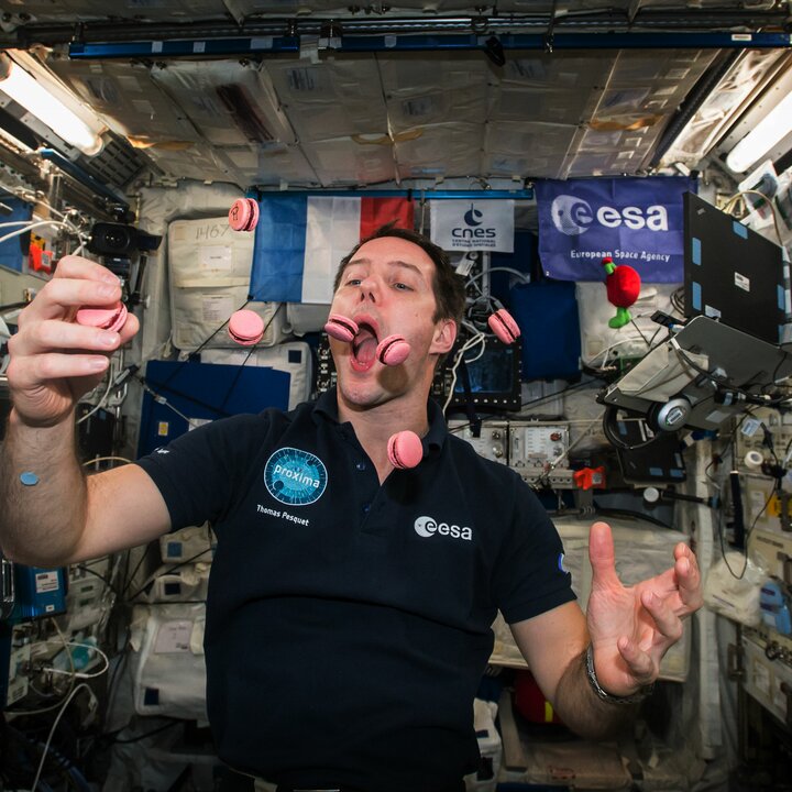 ESA Astronaut Thomas Pesquet auf der ISS mit Macarons in der Luft | © ESA/NASA