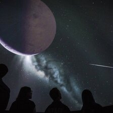 Menschen beobachten Planeten im Planetarium.