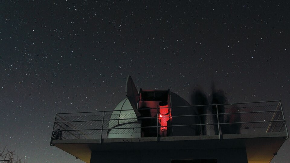 Blick auf die historische Schaerer-Sternwarte und ihr Teleskop bei Nacht, direkt neben dem Space Eye