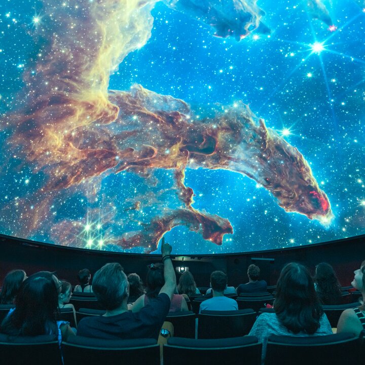 Menschen im Planetarium erleben eine Show, wie es auch im Space Eye auf der Uecht möglich ist.