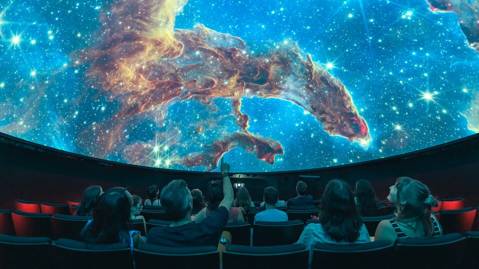 Menschen im Planetarium erleben eine Show, wie es auch im Space Eye auf der Uecht möglich ist.
