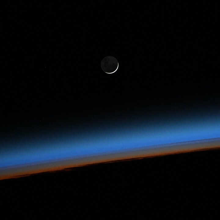 Ein aufgehender Neumond aufgenommen aus der International Space Station, zu erkennen ist die dünne Erdatmosphäre in blau und orange. | © ESA - S. Cristoforetti