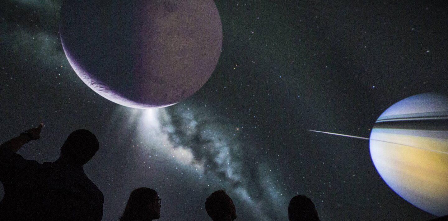 Familie schaut eine Planetariumsshow im Space Eye
